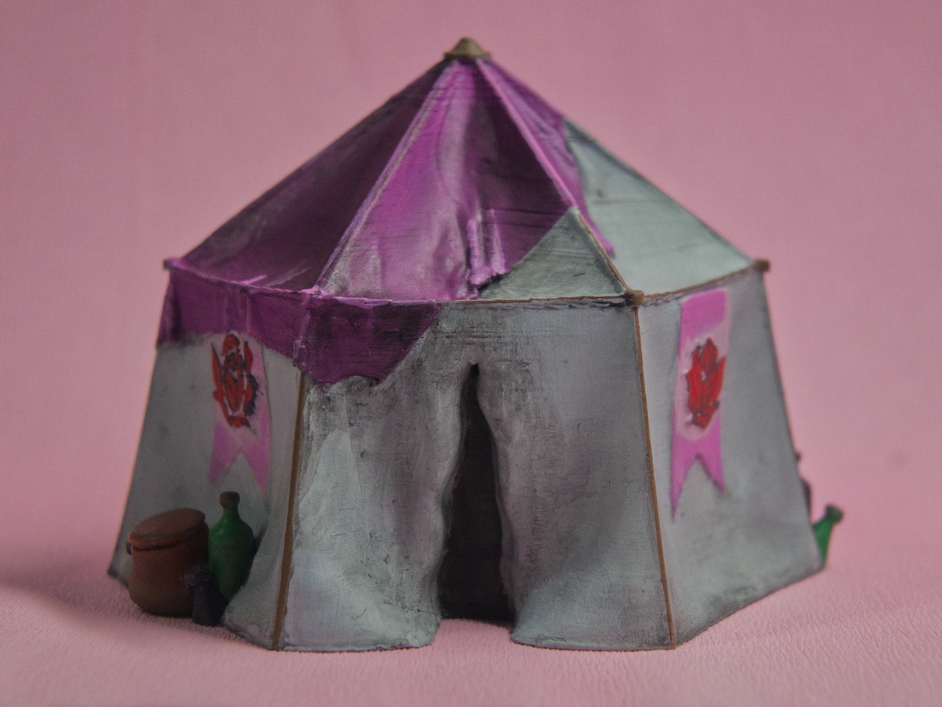 Ein großes sechs eck Zelt mit weißen wänden Rosen Bannern und pinkem abdecke Tuch  